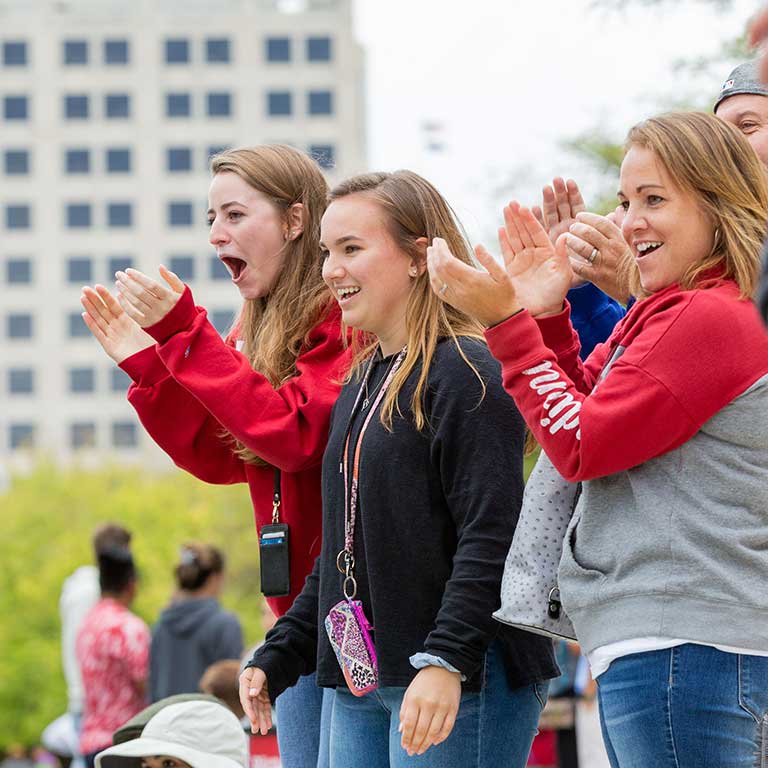 Students cheer on their friends on the side of the canal.